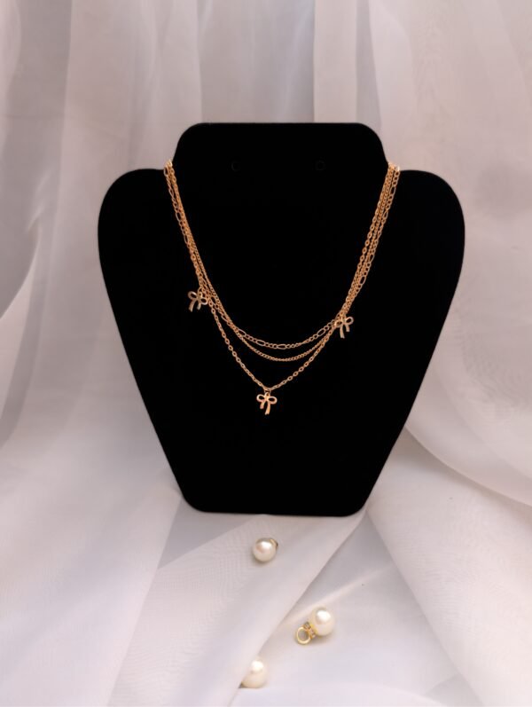 Trijų grandinėlių rinkinys su kaspinėliais ir perlu